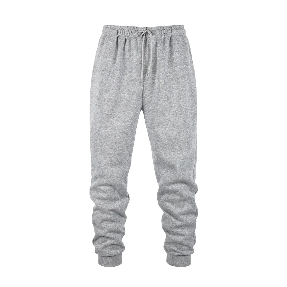 Men's gray fleece jogger sweatpants in soft polyester fabric with an elastic waistband and tapered cuffs. Designed for movement with moisture-wicking performance, ideal for workouts, lounging, or everyday wear.
