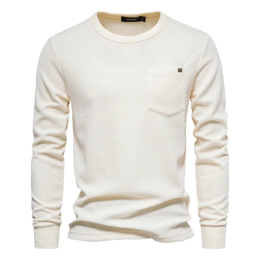 A women's long sleeve waffle-knit tee with a relaxed fit and chest pocket. The 80% cotton/20% polyester blend offers softness and breathability, with textured fabric that provides lightweight warmth. Designed for easy everyday wear in spring and fall seasons.