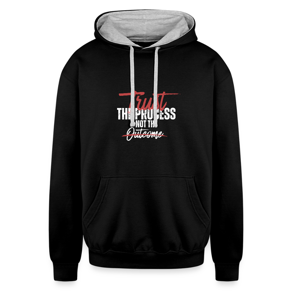 A unisex black/gray contrast hoodie featuring a double-layered hood with a bold contrasting inner fabric and matching flat lace drawcords. The front displays a motivational print reading "Trust the Process Not the Outcome" in a clean, modern font. Made from a soft 80% cotton/20% polyester blend (8.3 oz midweight fabric), it has ribbed cuffs and hem for a snug fit. Designed for tag-free comfort with a tear-out label, this stylish pullover by ADON LUXE is perfect for everyday wear. 