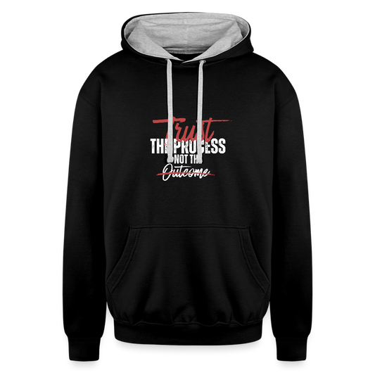 A unisex black/gray contrast hoodie featuring a double-layered hood with a bold contrasting inner fabric and matching flat lace drawcords. The front displays a motivational print reading "Trust the Process Not the Outcome" in a clean, modern font. Made from a soft 80% cotton/20% polyester blend (8.3 oz midweight fabric), it has ribbed cuffs and hem for a snug fit. Designed for tag-free comfort with a tear-out label, this stylish pullover by ADON LUXE is perfect for everyday wear. 